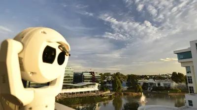 MIC IP fusion 9000i in front of building with lake