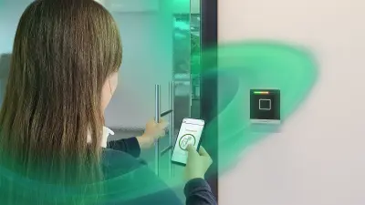 Woman using mobile phone to get access to an office